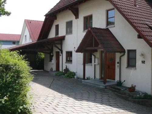 Casa blanca con techo rojo y entrada en Castle View Comfortable Holiday Residence, en Markdorf