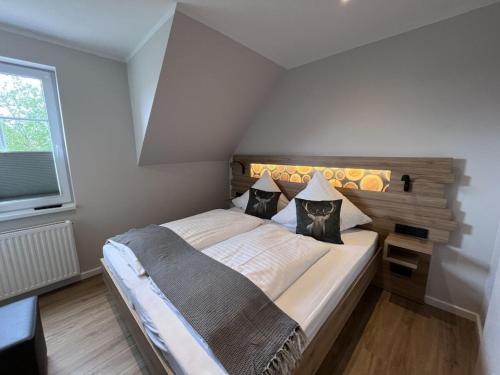 Un dormitorio con una cama grande con cabecero de madera. en Small mountain house Comfortable holiday residence, en Braunlage