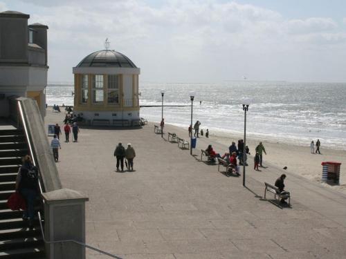 a group of people sitting on benches on the beach at Holiday Apartment Holly Comfortable holiday residence in Borkum