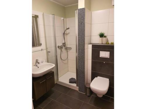 a bathroom with a shower and a toilet and a sink at Holiday Apartment Holly Comfortable holiday residence in Borkum