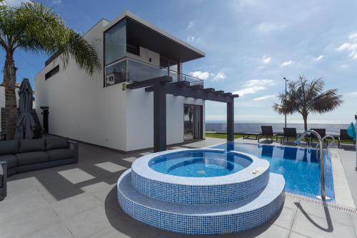 a villa with a swimming pool and a house at Villa Andrade Ocean View in Funchal