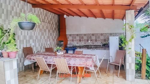 un tavolo con sedie e una cucina in un patio di Conforto e lazer em Ilheus perto da Praia da Perola a Ilhéus
