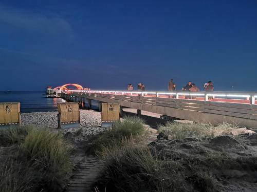 people standing on a pier at the beach at Ostseeferienpark Walkyrien - Bootsmann 09 in Schashagen