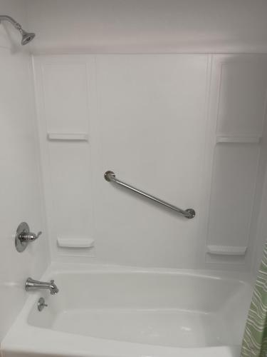 un bagno bianco con due rubinetti e un lavandino di Crawford Motel a Springfield