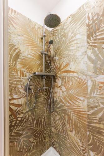 a shower in a bathroom with a palmrative wallpaper at casa dolce casa in Rome