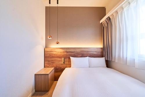 a bedroom with a bed and a window at Hotel Global View Hachinohe in Hachinohe