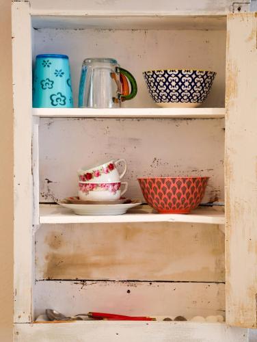 a shelf with bowls and cups on it at DAS TRAUFENHAUS AM WALL - Urlaub im Denkmal in Boizenburg