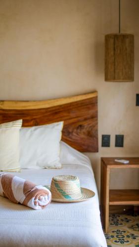 a bed with a hat on top of it at Mero Mero Hotel in El Cuyo