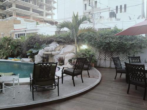 a group of chairs sitting on a patio next to a pool at Departamentos con Alberca in Mazatlán