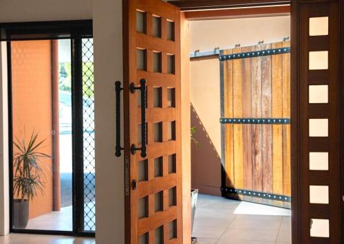 an open door leading to a room with a door at Lake House, stroll to beach & cafes- Pets Welcome in Trinity Beach