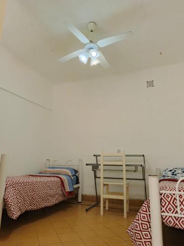 a ceiling fan in a room with two beds at Hostel Downtown Las Morenas in Buenos Aires
