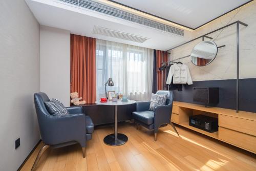a living room with a table and two chairs at Suisse place Hongqiao Shanghai in Shanghai