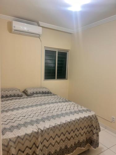 a bedroom with a bed and a window at Conjunto Residencial Jardim Atlântico in Olinda