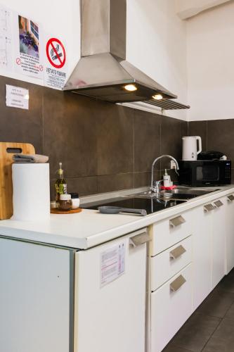 a kitchen with white cabinets and a sink at casa dolce casa in Rome