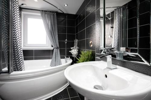 a black and white bathroom with a sink and a tub at Spacious 3 Bed Home in Glasgow City With Free Parking in Glasgow