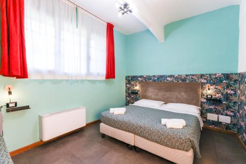 a bedroom with a bed with blue walls and red curtains at casa dolce casa in Rome