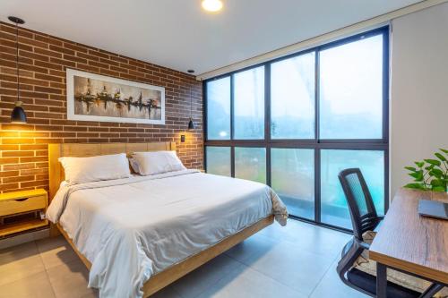 a bedroom with a bed and a brick wall at View & Lake Access 5min To Town in Guatapé