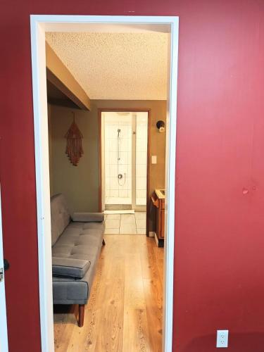 a living room with a couch and a red wall at Cozy 7BR Farmhouse with Pool, Hot Tub, Sauna and More in Langley