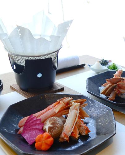 two plates of food sitting on a table with food at 森のオーベルジュ 三 みつ - 旧 森厚真hotel CHUPKI - in Chitose