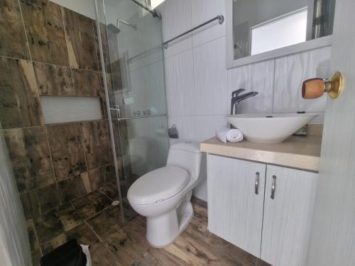 a bathroom with a toilet and a sink and a shower at Apartahotel Rubí San Gil in San Gil