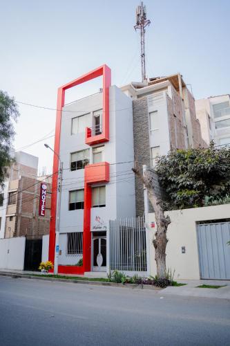 a white building with red trim on the side of a street at TruGarden Hotel Trujillo in Trujillo