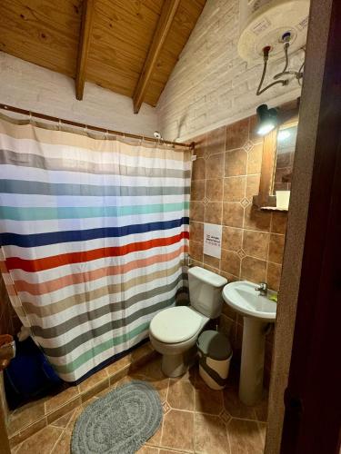 a bathroom with a toilet and a sink at Cabañas Country in La Paloma