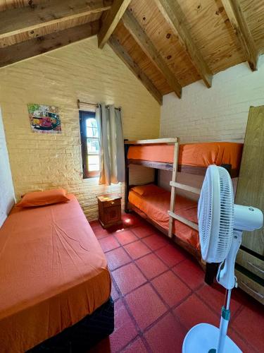 a room with two bunk beds and a fan at Cabañas Country in La Paloma