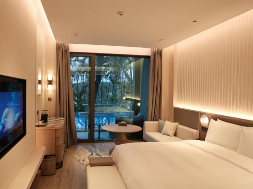 a hotel room with a large bed and a television at C&D Hotel Dongshan Zhangzhou in Tongling