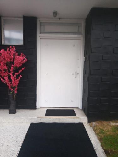 a garage with a white door and a vase of flowers at Colisseum Roma House- Campin Simón Bolivar Movistar Embajada compensar in Bogotá
