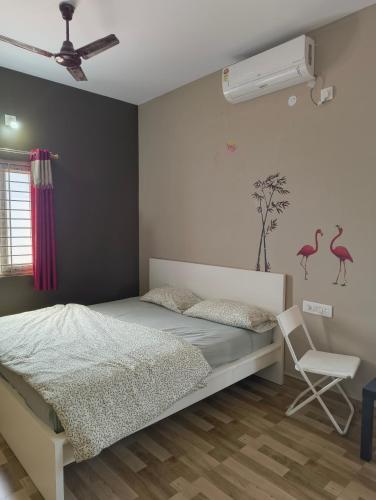 a bedroom with a bed and a chair at Jai Anjaneya Guesthouse in Devanahalli-Bangalore