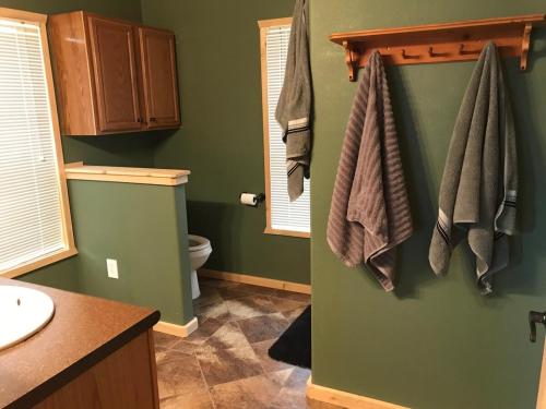 a bathroom with a toilet and towels hanging on the wall at Amazing views near Strawberry Point! in Duck Creek Village