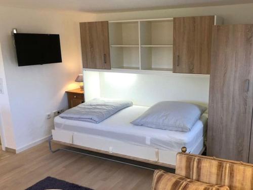 a bedroom with a bed and a tv on a wall at Apartment Grünsberg Comfortable holiday residence in Grünsberg