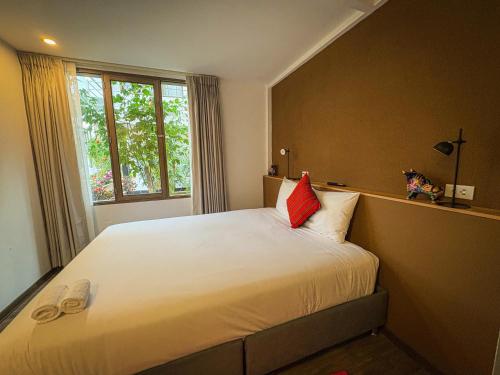a bedroom with a large white bed with a window at MUJU hotel by Ämak in Urubamba