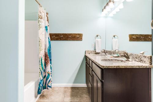 un baño con lavabo y bañera en Boogie Board Bungalow - Pet Friendly PRIVATE POOL 2, en Port Aransas