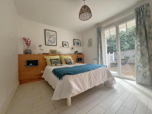 une chambre avec un lit et une grande fenêtre dans l'établissement Charmante Villa avec Terrasse et Garage à Arcachon, Proche Centre et Plages - FR-1-474-61, à Arcachon