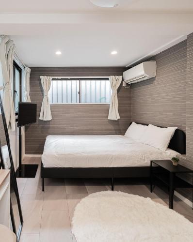 a bedroom with a large bed and a window at MX House - Cozy APT Stay in Ikebukuro Tokyo, with Direct Access to Shinjuku & Shibuya in Tokyo