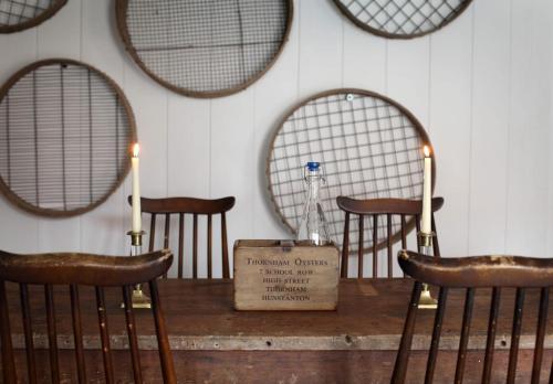 a wooden table with two chairs and two mirrors at Black Lion Hotel in Little Walsingham