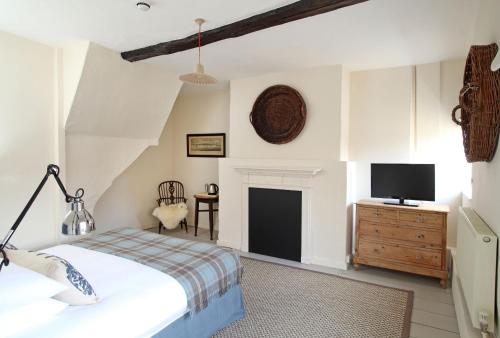 a bedroom with a bed and a tv on the wall at Black Lion Hotel in Little Walsingham