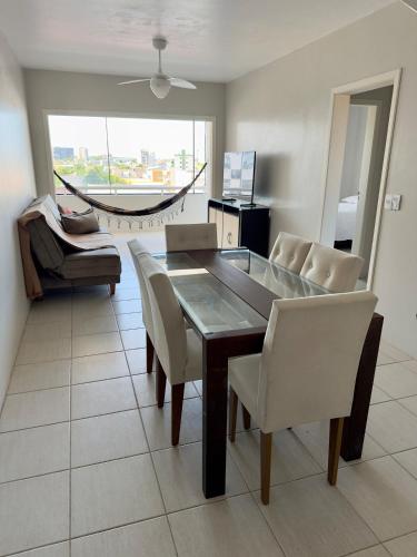a dining room with a table and chairs and a hammock at Cobertura duplex 3 quartos, centro, terraço e churrasqueira, ideal para família, acesso por escadas in Torres