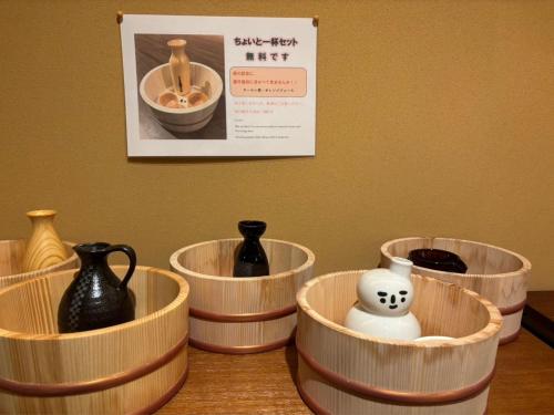 a group of vases in wooden containers on a table at Mogamitakayu Zenshichinoyu Ohira in Zao Onsen