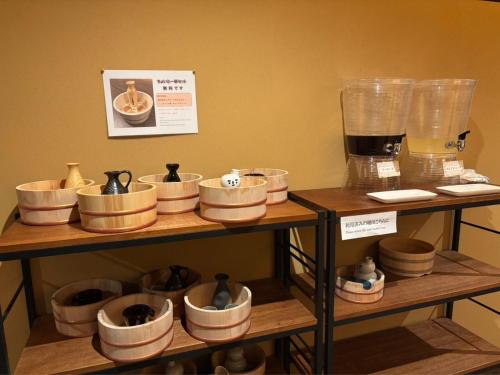 a display of bowls and plates on wooden shelves at Mogamitakayu Zenshichinoyu Ohira in Zao Onsen