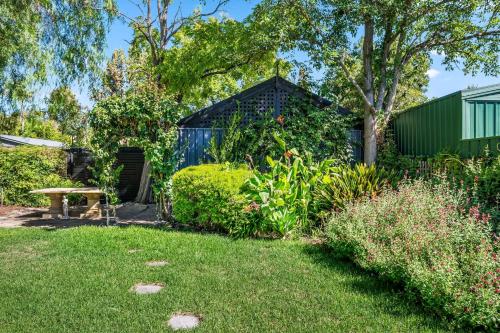 a garden with a blue building in the background at Mediterranean Muse - 3BR, Wi-Fi, Parking in Unley