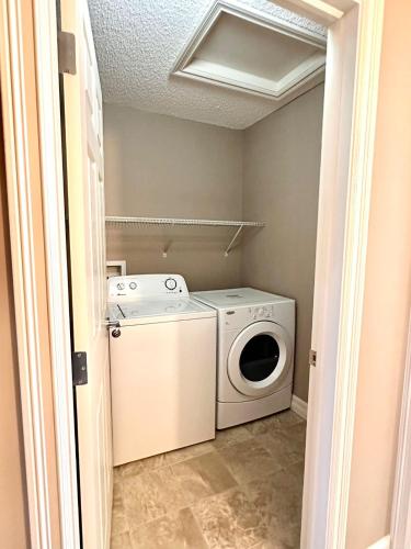 a washer and dryer in a small laundry room at Entire Beautiful and Cozy Home in Edmonton