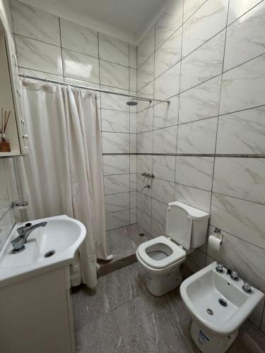 a white bathroom with a toilet and a sink at Quinta Estrella in San Pedro