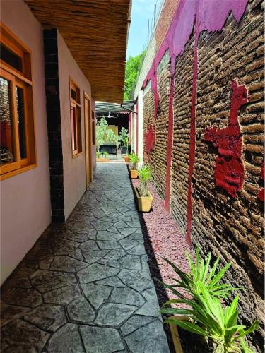 a stone walkway next to a brick building with plants at Casa Cañonero, a magic place, 4 room in Oaxaca City