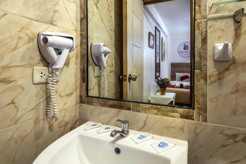 a bathroom with a sink and a phone on the wall at Runas Inn Machupicchu in Machu Picchu