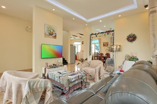 a living room with a couch and a tv at The Hill An Sơn DIC in Xuan An