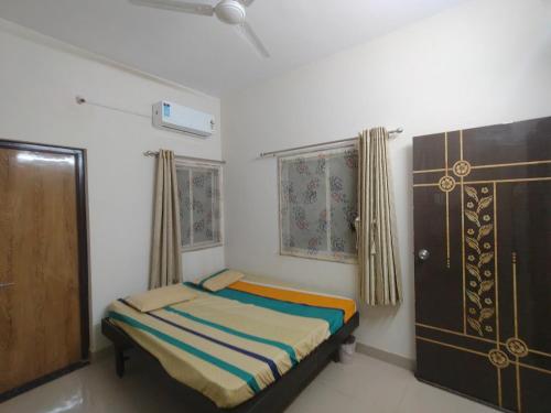 a small bedroom with a bed and a door at My Nest - Best Homestay for Peaceful Stay with Comfort in Bhuj