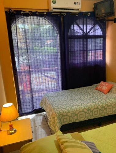 a small room with two beds and a window at Casa central in San Juan del Sur