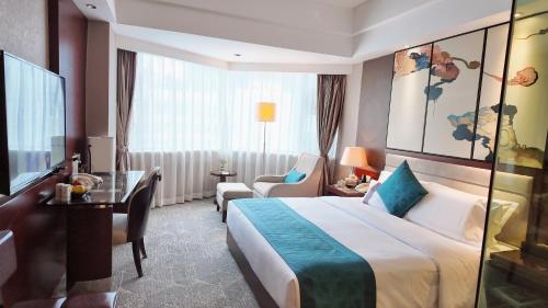 a hotel room with a large bed and a desk at Kunming Haitian Hotel in Kunming